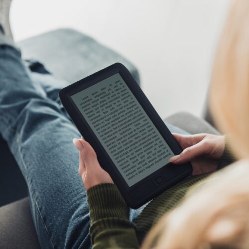 cropped view of woman reading ebook at home